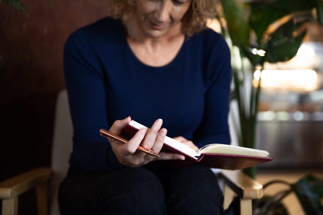 Jacqui Alder reading a copy of her self-coaching journal for women
